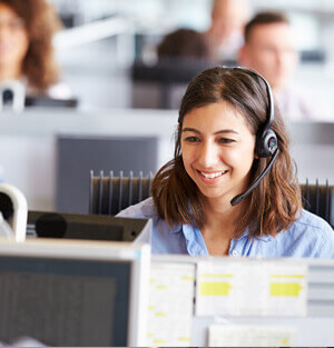 Customer Service representative smiling while talking on a headset